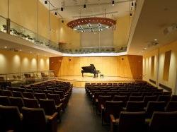 Piano on lit stage at John J Cali School of Music, Leshowitz Hall.