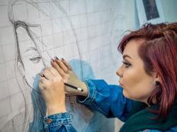 艺术学院的学生在墙上用铅笔在大方格纸上画肖像.
